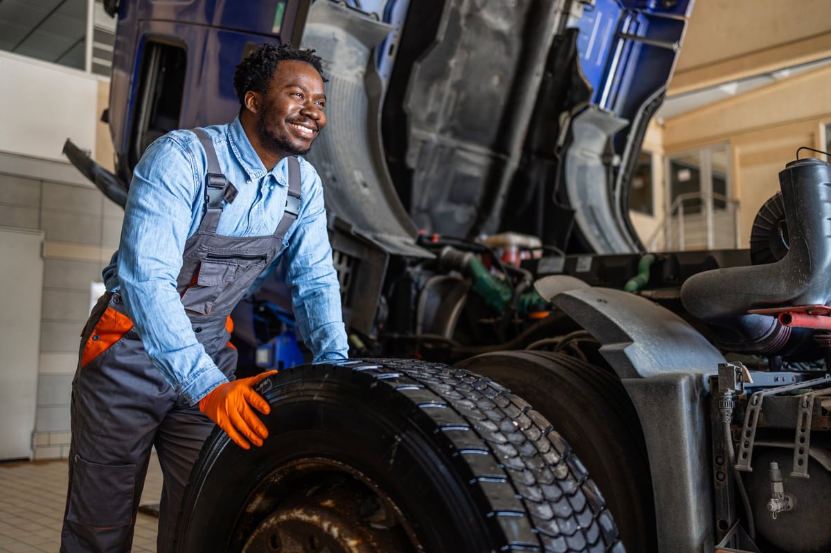 Mechanic replacing a truck wheel and repairing a flat tire