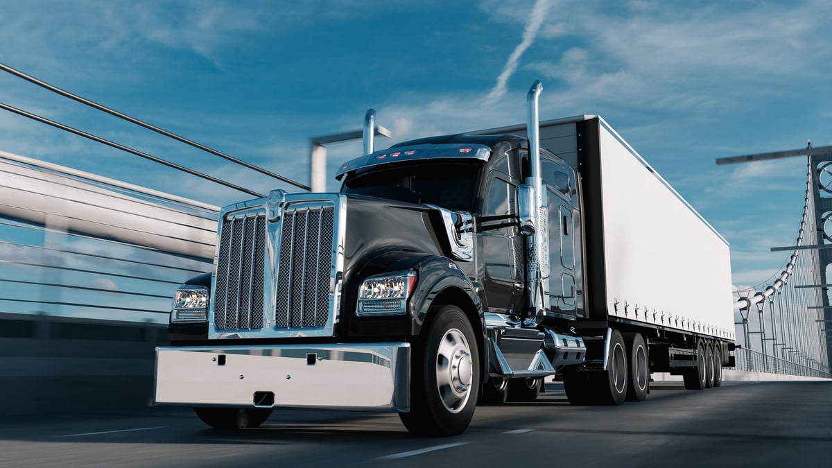 A heavy commercial truck pulling a load on a freeway