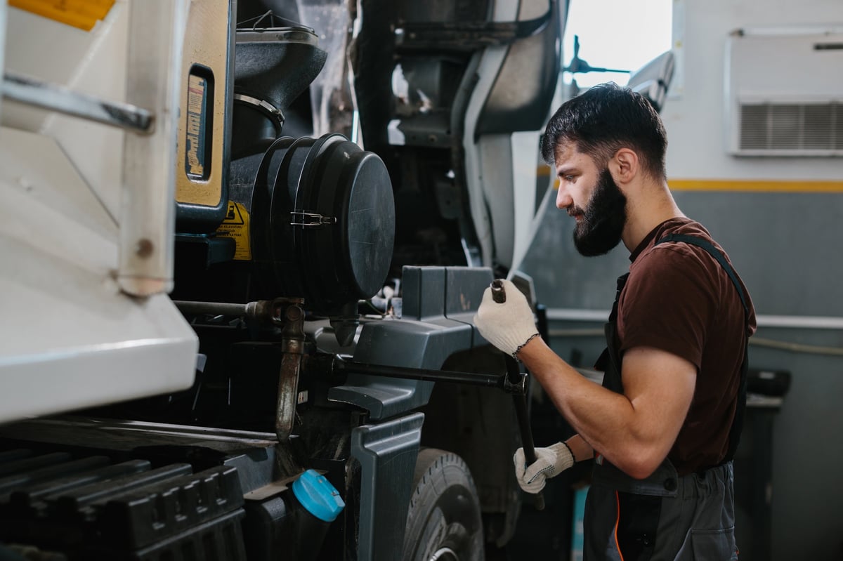 A mechanic working on a truck engine in a workshop