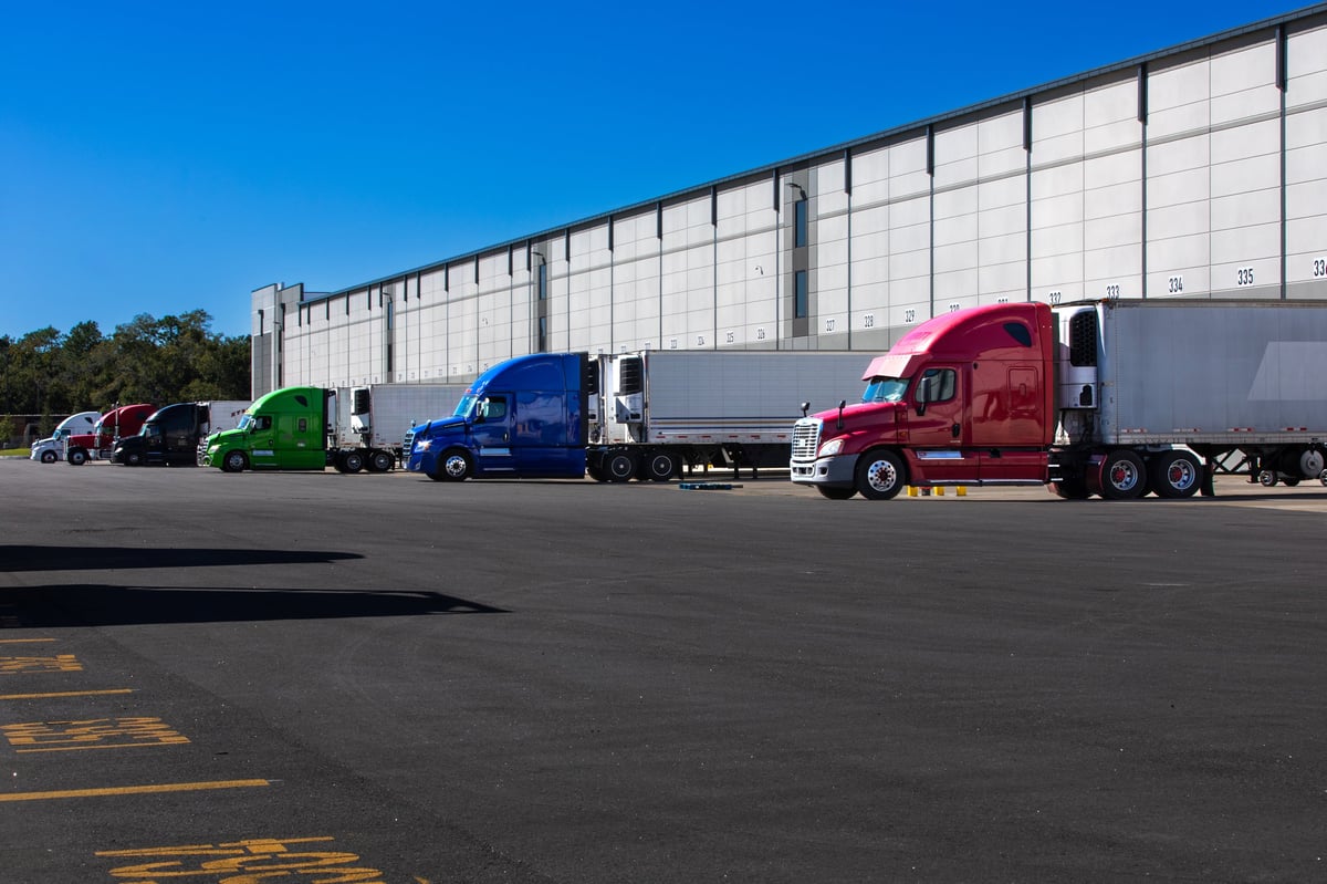 Semi trucks parked at a warehouse loading dock