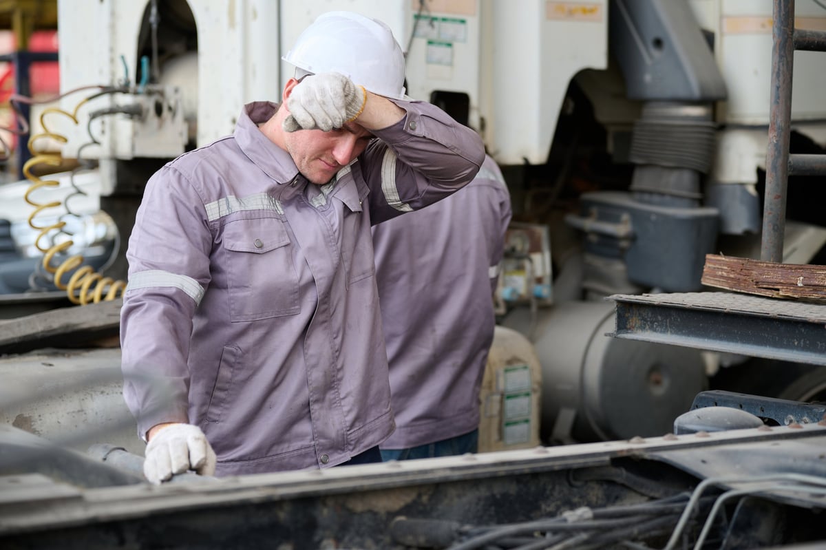 A hardworking fleet technician taking a break beside service trucks
